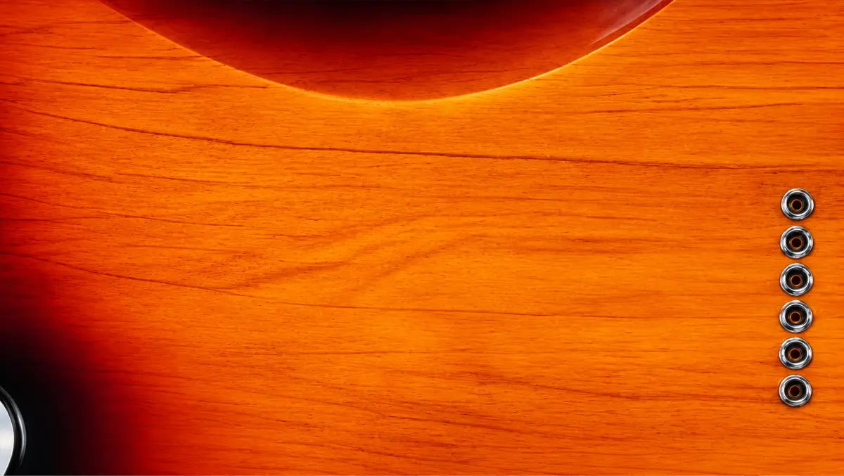 Close-up of a sunburst guitar body and tuning pegs