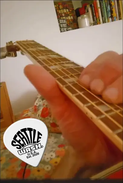 Poster frame from a lesson video: close-up of hands on a fretboard with the Seattle pick logo
